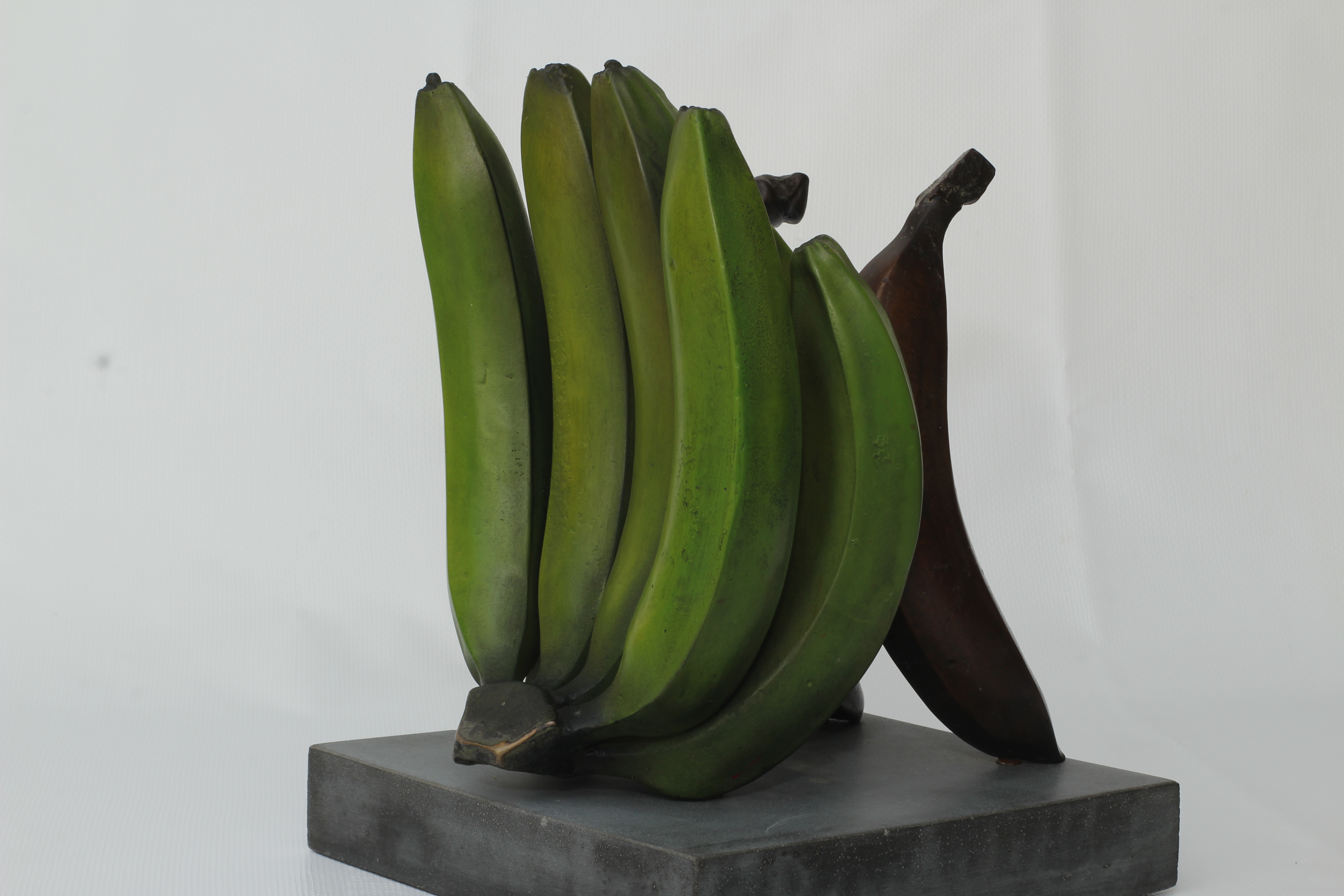 Finished Musa transmutate — Lacatan hand with red banana on cement plinth